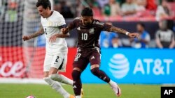 El defensa uruguayo José María Giménez, a la izquierda, lucha con el mediocampista mexicano Alexis Vega en la segunda mitad de un partido amistoso internacional de fútbol, el miércoles 5 de junio de 2024 en Denver.