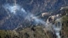 FILE - A U.S. Army Apache helicopter flies over Afghanistan's Kunar province, June 4, 2012.