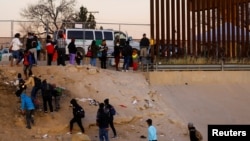 Migrantes que buscan asilo salen del río Bravo después de cruzarlo para entregarse a los agentes de la Patrulla Fronteriza de EEUU en El Paso, Texas, el 17 de diciembre de 2022. REUTERS/José Luis González
