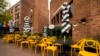 FILE - Empty chairs lines a sidewalk outside a restaurant Washington's Georgetown district, April 29, 2020. 