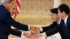 U.S. Secretary of State John Kerry, left, U.S. Defense Secretary Chuck Hagel, second from left, Japanese Defense Minister Itsunori Onodera second from right, and Japanese Foreign Minister Fumio Kishida, shake hands before the Japan-US 2+2 meeting in Tokyo, Oct. 3, 2013.