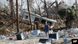 Ronnie Poole camina a través de los escombros mientras revisa la casa de un amigo después del huracán Michael en Mexico Beach, Florida, el 17 de octubre de 2018.