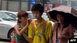 A Chinese family eats ice cream to stay cool as high temperatures continue in Beijing, August 6, 2013.
