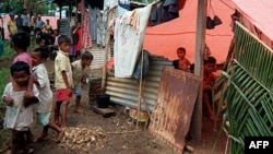 People shelter from the heat of sun in a refugee camp in Morotai, North Maluku, June 21, 2000.