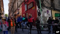 Mineros de oro descansan sobre una barricada policial durante una protesta en las calles de La Paz, Bolivia, el 25 de octubre de 2022.