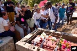 Familiares del minero Santiago Mora lloran durante su entierro en el cementerio de La Paragua, estado Bolívar, Venezuela, el jueves 22 de febrero de 2024. (Foto AP/Ariana Cubillos)