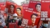 FILE - Demonstrators hold placards depicting deposed Myanmar leader Aung San Suu Kyi during a protest against the military coup, in Naypyitaw, Myanmar, Feb. 17, 2021.