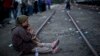 An Afghan refugee woman holding her daughter rests while waiting to board a train heading to the Austrian border, in Roszke, southern Hungary, Sept. 14, 2015. 