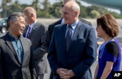 El jefe de gabinete del presidente Donald Trump, John Kelly, en el centro, habla con el gobernador de Hawai David Ige, a la izquierda, y su esposa, Dawn, mientras el presidente Donald Trump llega a la Base Conjunta Pearl Harbor Hickam, Hawai, el 3 de noviembre de 2017.