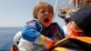 A child migrant is brought onto the Malta-based NGO Migrant Offshore Aid Station (MOAS) ship Phoenix during a rescue operation in the central Mediterranean, in international waters off the Libyan coastal town of Sabratha, May 4, 2017.