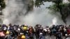 Protesters react after police fired tear gas during a demonstration against the military coup in Mandalay, Myanmar, March 3, 2021. 