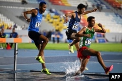 Carlos Sanmartín de Colombia, Carlos Santos de El Salvador y César Gómez de México compiten durante la final masculina de 3.000 metros con obstáculos en los XXIV Juegos Centroamericanos y del Caribe en San Salvador el 7 de julio de 2023. (Foto de MARVIN RECINOS / AFP)