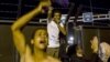 Migrants shout slogans in front of a barrier at the border with Hungary near the village of Horgos, Serbia, Sept. 15, 2015. 