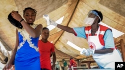 Pessoas vindas da Rep. Dem. do Congo vistas por técnicos de saúde para medir a temperatura devido ao ébola, na fronteira de Mpondwe no Uganda. 14 Junho, 2019.
