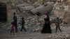 FILE - Iraqi civilians are seen walking past the destroyed al-Nuri mosque in the Old City of Mosul, Iraq, July 4, 2017.