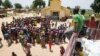 FILE - People queue for food aid distribution delivered by the United Nations Office for the Coordination of Humanitarian Affairs and world food program in the village of Makunzi Wali, Central African Republic, April 27, 2017.
