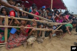 FILE - Rohingya children, who crossed over from Myanmar into Bangladesh, are squashed together as they wait to receive food handouts at Thaingkhali refugee camp, Bangladesh, Oct. 21, 2017.