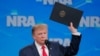 US President Donald Trump holds up an executive order as he announces the United States will drop out of the Arms Trade Treaty during a speech at the National Rifle Association-Institute for Legislative Action's148th annual meeting in Indianapolis, Indiana, U.S., April 26, 2019.
