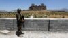 FILE - An Afghan National Army soldier stands guard after the inauguration of the reconstruction project to restore the ruins of historic Darul Aman palace, in Kabul, Afghanistan, May 30, 2016