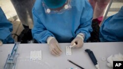 Personal de salud realiza pruebas rápidas para el coronavirus en el mercado de Coche en Caracas, Venezuela. Junio 23, 2020.