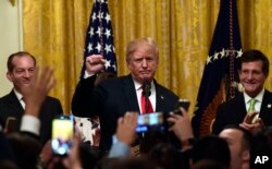 El presidente Donald Trump (centro) en la celebración del Mes de la Herencia Hispana en la Casa Blanca, acompañado a la izquierda por el vicegobernador de Puerto Rico Luis Rivera Marín, y a la derecha, el secretario de salud Alex Acosta. Septiembre 17 de 2018.