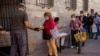 People collect food donated by volunteers and members of the Catholic Servants of Jesus congregation in Madrid, Spain, Oct. 8, 2020.