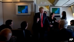 El Presidente Donald Trump habla con los periodistas a bordo del Air Force One, mientras viaja al Aeropuerto Internacional de Palm Beach en West Palm Beach, Florida.
