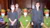 អ្នក​កាសែត​របស់​សមាគម​អ្នក​កាសែត​ឯករាជ្យ​វៀតណាម លោក Pham Chi Dung​ (ស្ដាំ) លោក Le Huu Minh Tuan (កណ្ដាល) និង​លោក​ Nguyen Tuong Thuy (ឆ្វេង) ឈរ​នៅ​ចន្លោះ​ប៉ូលិស ក្នុង​អំឡុងពេល​នៃ​សវនាការ​របស់​ពួកគេ​នៅ​ទីក្រុង​ហូជីមិញ ប្រទេស​វៀតណាម ថ្ងៃទី៥ ខែមករា ឆ្នាំ២០២១។ 