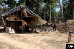 Un niño corre afuera de una choza en el pueblo de Bulla Loca, estado de Bolívar, Venezuela, el 22 de febrero de 2024, a medio camino entre la ciudad de La Paragua y la mina ilegal Bulla Loca, que colapsó el 20 de febrero. (Foto de Pableysa OSTOS/AFP)
