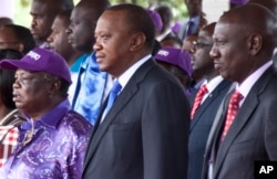 Kenyan President Uhuru Kenyatta, center, with Francis Atwoli, General Secretary of The Central Organization of Trade Unions (COTU) Kenya, left, and Kenyan Vice President William Ruto, right, watch the Labor Day Celebration Parade at Uhuru Park, Nairobi, Kenya, May 1, 2017.