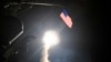 FILE - The guided-missile destroyer USS Porter launches a tomahawk land attack missile from the Mediterranean Sea, April 7, 2017.