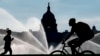 ARCHIVO - El Capitolio se ve mientras los rociadores de agua empapan el National Mall en una calurosa mañana de verano en Washington, el 15 de julio de 2022.
