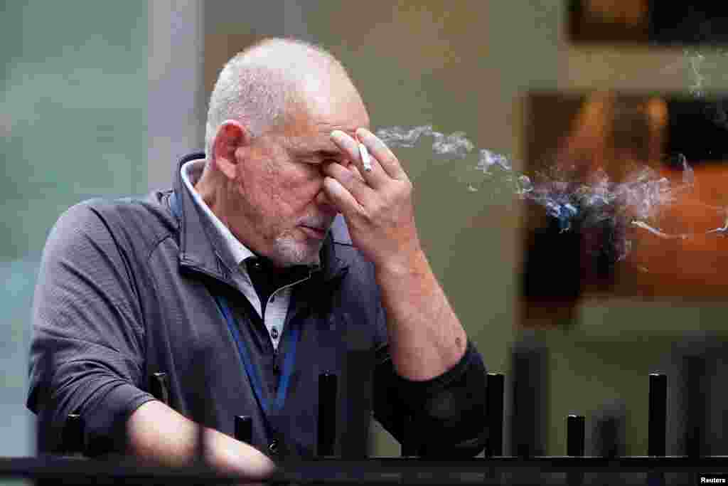 Un hombre fuma un cigarrillo fuera de la Bolsa de Valores de Nueva York en el distrito de Manhattan de la ciudad de Nueva York, dos días después de las elecciones presidenciales de EE.UU., 2020, Nueva York, 5 de noviembre de 2020.