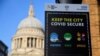 FILE - A public health information sign is seen with St. Paul's Cathedral seen behind amidst a lockdown during the spread of the coronavirus disease (COVID-19) pandemic, London, Britain, Jan. 7, 2021. 