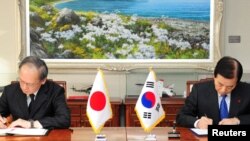 한민구 한국 국방장관(오른쪽)과 나가미네 야스마사 주한일본대사가 23일 서울 용산구 국방부에서 2급이하 군사비밀을 직접 공유하는 군사비밀정보보호협정(GSOMIA)을 체결하고 있다.