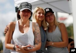 Desde la izquierda, Michaela Stilwell, Melinda Stilwell y Taylor Curtis asisten a un servicio de oración en el aniversario del tiroteo masivo del 1 de octubre de 2017, el lunes 1 de octubre de 2018 en Las Vegas. Michaela Stilwell y Taylor Curtis asistieron al festival de música country el año pasado y regresaron a Las Vegas para el aniversario. (AP Photo / John Locher)