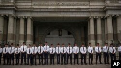 ARCHIVO - Los cadetes de la Academia Nacional de Policía se encuentran afuera del Palacio Nacional de la Cultura mientras observan a la gente marchar para conmemorar la Revolución de 1944 en la Ciudad de Guatemala, el viernes 20 de octubre de 2023.