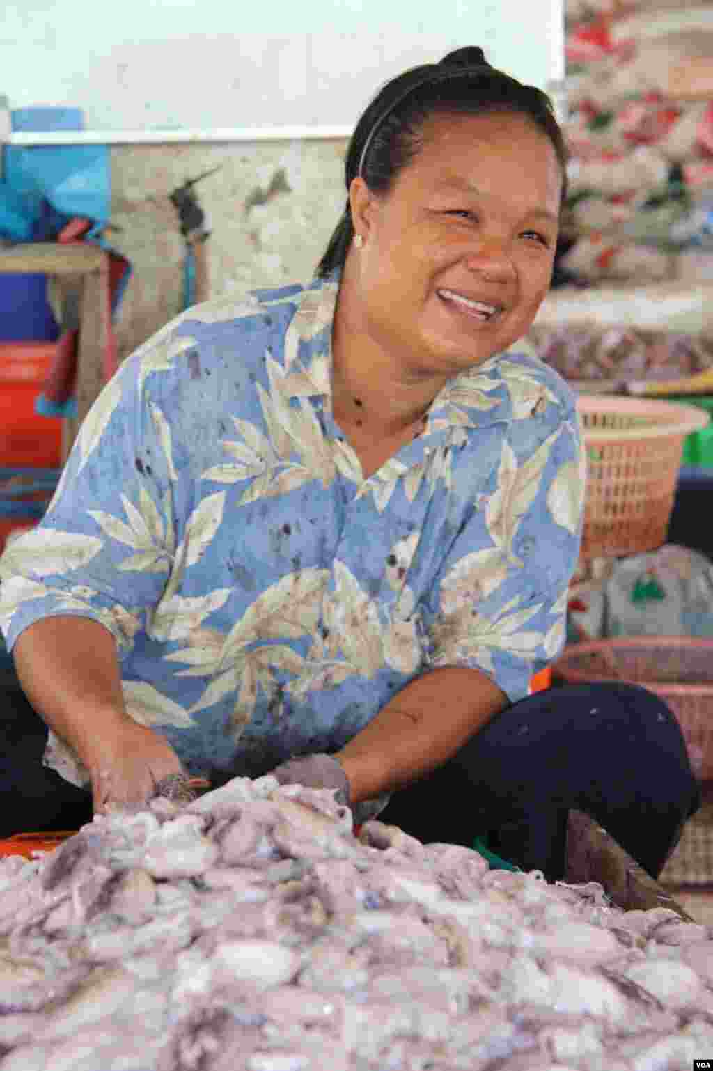 A Burmese woman sorts and cleans squid at Talay Thai in Samutsakhon, Thailand, December 20, 2012. (VOA/D. Schearf)