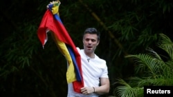 Leopoldo López saluda a sus seguidores que lo viraron frente a su casa, donde permanece ahora bajo arresto domiciliario.