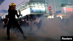 Manifestantes reaccionan a gases lacrimógenos lanzados por la policía en Hong Kong el 20 de octubre de 1019 (Foto REUTERS/Tyrone Siu)