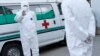 FILE - Medical personnel in protective suits stand by an ambulance at the Sunan International Airport in Pyongyang, North Korea.