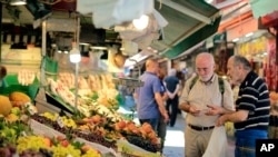 FILE - A man shops in a market in Istanbul, Monday, Aug. 13, 2018.