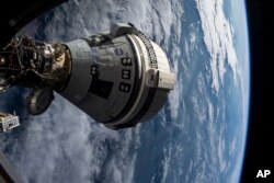 Архівне фото НАСА: космічний корабель Boeing Starliner пристикований до модуля Harmony Міжнародної космічної станції 3 липня 2024 року, видно з вікна космічного корабля SpaceX Dragon Endeavor, пристикованого до сусіднього порту.