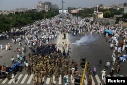 Police try to stop farmers during a protest demanding a better price for their produce on the outskirts of New Delhi, India, Oct. 2, 2018.