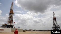 Un trabajador camina junto a las plataformas de perforación en un pozo de petróleo operado por la petrolera estatal de Venezuela PDVSA, en el rico cinturón petrolero del Orinoco, el 16 de abril de 2015.m Foto: Reuters.