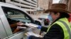 Jill Mickelson helps a drive up voter outside the Frank P. Zeidler Municipal Building Monday March 30, 2020, in Milwaukee. 
