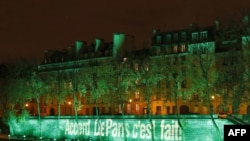 FILE - The Ile Saint-Louis is illuminated with the lettering reading 'The Paris accord is done' in Paris, Nov. 4, 2016, to mark the first day of the enforcement of the Paris COP21 climate accord. 
