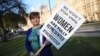 FILE - Labour Party member of Parliament Emily Thornberry holds a placard at an event to mark the 100th anniversary of the enfranchisment of some, but not all women, outside the Houses of Parliament in London, Britain, Feb. 6, 2018.