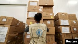 ARCHIVO - Un trabajador del Programa Mundial de Alimentos arregla paquetes de ayuda humanitaria a África para combatir el brote del coronavirus. Aeropuerto Internacional Addis Ababa, Etiopía.