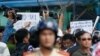 Police and security personnel film protesters holding placards which read, "Haiyang 981 oil rig get out of Vietnam (left)" and "Take China to the international court" (right) during an anti-China protest in Vietnam's southern Ho Chi Minh city May 18, 2014.